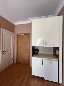 une cuisine avec des placards blancs et une porte dans l'établissement Zendy Suite Hotel, à Istanbul
