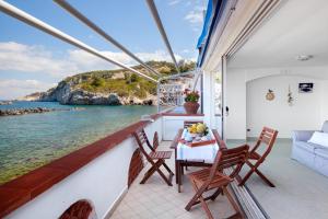 a balcony with a table and chairs and a view of the ocean at Casa Vacanza Verde Smeraldo- (San Montano) in Massa Lubrense