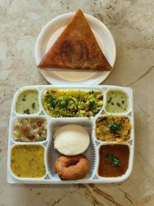 un vassoio di alimenti con diversi tipi di alimenti di Yuvraj Galaxy Inn a Mysore