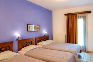 A bed or beds in a room at Artemis Hotel
