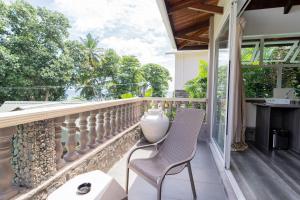 a balcony with two chairs and a fireplace at Romance Bungalows in Beau Vallon
