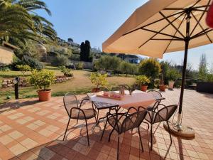 a table and chairs with an umbrella on a patio at B&B Corte Frisonai in Bardolino