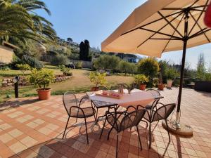 una mesa y sillas con una sombrilla en el patio en B&B Corte Frisonai, en Bardolino