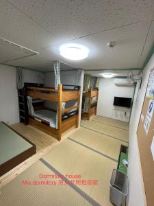 a room with two bunk beds and a ceiling at Dormitory Sandanya Guesthouse in Shirahama