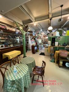 un restaurante con mesas y sillas en una habitación en Dormitory Sandanya Guesthouse en Shirahama