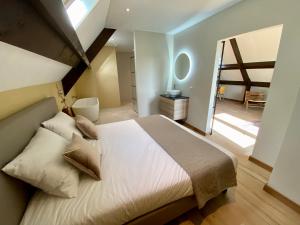 1 dormitorio con 1 cama blanca grande y baño en LooSan Lodges, en Reutum