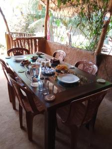 una mesa de madera con platos de comida. en Kalimetiya Beach Cabana, en Hungama