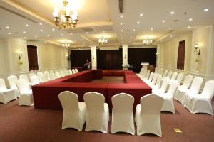 une grande salle de réunion avec une table rouge et des chaises blanches dans l'établissement CityBay Palace Hạ Long Hotel, à Hạ Long