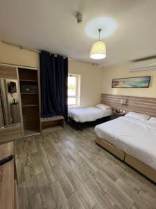 a hotel room with two beds and a window at La Riva Hotel in Aqaba +33 photos