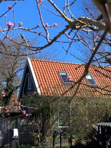 una casa con techo de baldosas rojas en het zwaluwnest, en Koudekerke