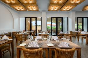 ein Restaurant mit Holztischen, Stühlen und Fenstern in der Unterkunft Absolute Kiotari Resort in Asklipiḯon