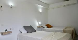 2 camas en una habitación con paredes blancas en Viviendas Margarita II, en Colonia de Sant Jordi