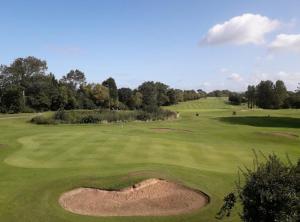 a view of a golf green with a bunker at Magenta Melodies, 5 Bedroom House in Blackpool
