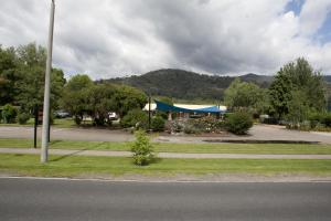 un estacionamiento con un edificio con una tienda azul en Snowgum Motel en Mount Beauty