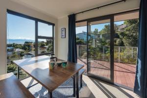 a dining room with a table and large windows at Blue Water Views in Nelson