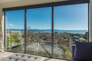 un salon avec une grande fenêtre donnant sur une ville dans l'établissement Blue Water Views, à Nelson