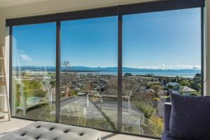 a living room with a large window looking out at a city at Blue Water Views in Nelson