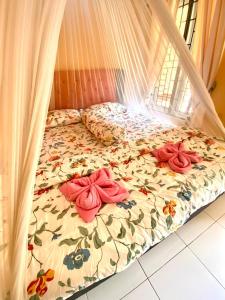 a bed with a comforter with flowers on it at Sumatra Cheeky Monkeys in Bukit Lawang