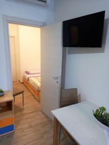 een woonkamer met een bed en een televisie aan de muur bij Parco dei Gerani in Formia