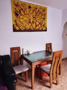a dining room table with chairs and a painting on the wall at Habitación tranquila y familiar in Madrid