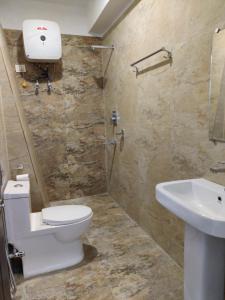 a bathroom with a toilet and a sink at Hotel Yangbum in Gangtok