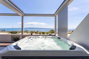 a bath tub in a room with a large window at Apartments Blue Maris Žnjan in Split