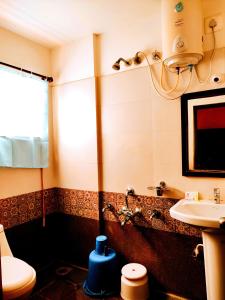 een badkamer met een wastafel en een toilet bij Yuvraj Galaxy Inn in Mysore