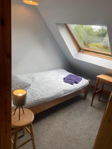 a small bedroom with a bed and a window at Barfad Self Catering Holiday Cottages in Tarbert