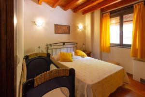 a bedroom with a bed with yellow pillows on it at Apartamentos Turisticos La Alqueria De Valverde in Valverde de los Arroyos