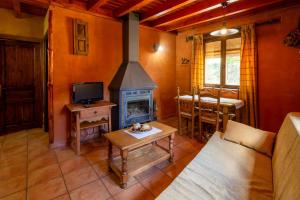 uma sala de estar com uma lareira, uma mesa e um sofá em Apartamentos Turisticos La Alqueria De Valverde em Valverde de los Arroyos