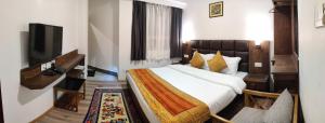 Habitación de hotel con cama y TV de pantalla plana. en Hotel Yangbum en Gangtok