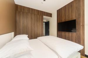 sypialnia z białym łóżkiem z drewnianym zagłówkiem w obiekcie Apartament Shellter Sun&Sea Rogowo koło Kołobrzegu_Dźwirzyno_nocleg w Rogowie