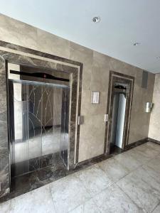 an empty room with a wall with a glass door at Apartment on Nizami street in Baku