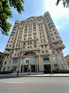 un edificio alto con gente caminando delante de él en Apartment on Nizami street, en Baku