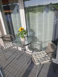 - une table et des chaises sur une terrasse couverte avec un tournesol dans l'établissement Ferienwohnung - Nachtigall, à Bad Hersfeld
