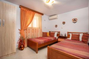 a bedroom with two beds and a window at Maia Luxury Pool Villa in Afantou