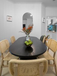 a black dining room table with a bowl of fruit on it at VENUS Central Sydney - FEMALE ONLY HOSTEL in Sydney