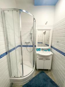 baño blanco con ducha y lavamanos en Solne Apartamenty Luna, en Wieliczka
