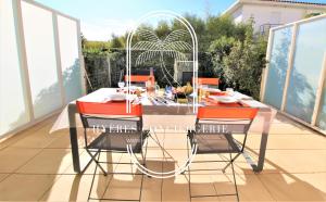 a table and four chairs on a balcony at Au bout de la rue la Mer- T3 Jardin Piscine PARKING WIFI BY HC in Carqueiranne