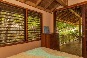 a bedroom with windows and a wooden deck at Tropical Breeze in Palmetto Bay in Palmetto Bay