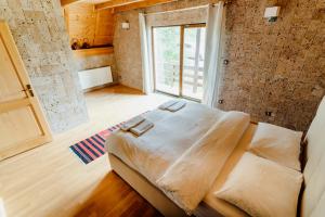 a large bed in a room with a large window at VillaLaylaRostovo in Bugojno