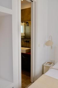 een slaapkamer met een bed en een badkamer met een wastafel bij MILORA SuNSET in Pollonia
