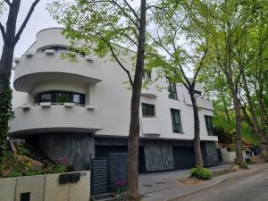 a white house with trees in front of it at Baltivia Haus II in Gdynia