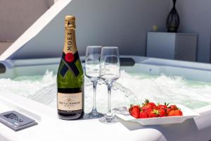 a bottle of champagne and two glasses on a table with strawberries at Apartments Blue Maris Žnjan in Split