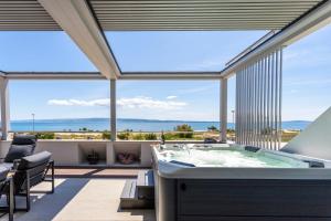 a jacuzzi tub in a room with large windows at Apartments Blue Maris Žnjan in Split