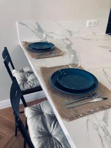 a table with blue plates and silverware on a counter at Le Cottage Bellifontain proche Château - INSEAD - Grand Parquet in Fontainebleau +35 photos