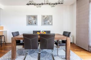 a dining room with a wooden table and black chairs at Apartments Blue Maris Žnjan in Split