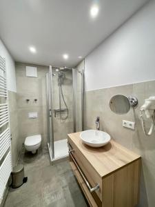 a bathroom with a sink and a shower and a toilet at Ferienhotel Alter Bahnhof garni in Prerow