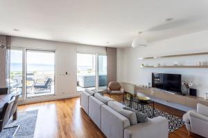 a white living room with a couch and a television at Apartments Blue Maris Žnjan in Split