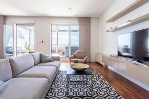a living room with a couch and a tv at Apartments Blue Maris Žnjan in Split